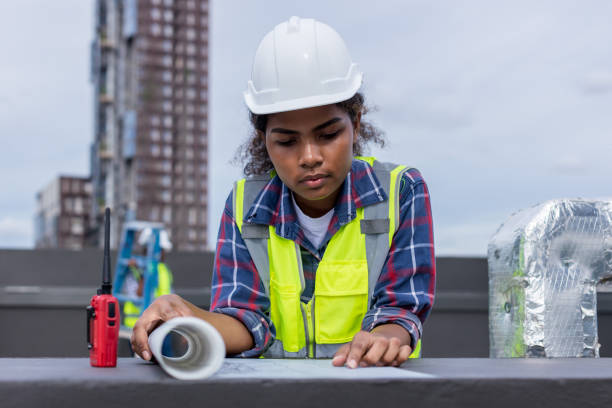 Engineers with draft plan of building on constructing site. Engineer working on building site. Engineer working with drawing System plan document