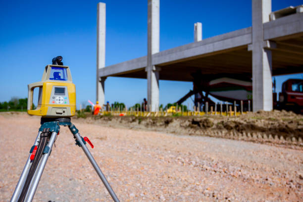 Total center device on tripod with laser for leveling other devices to level construction site.